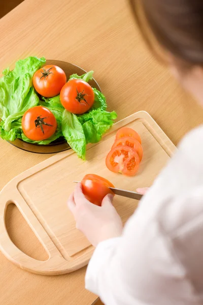 Las manos de mujer cortando tomate — Foto de Stock