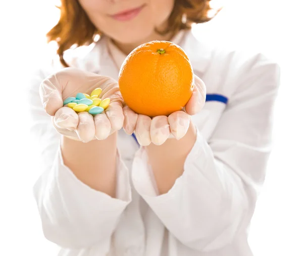 Woman's hands with orange and tablets — Stock Photo, Image