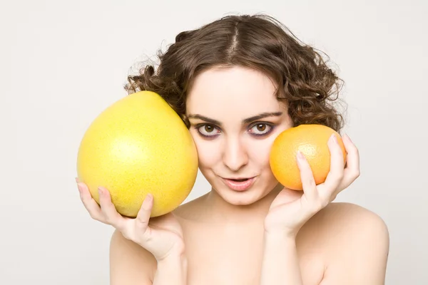 Красивая кудрявая девушка держит грейпфрут и Помело — стоковое фото