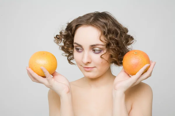Beautiful girl holding grapefruits — Stock Photo, Image