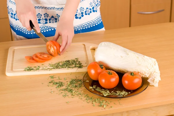 Kvinnans händer skära tomat — Stockfoto