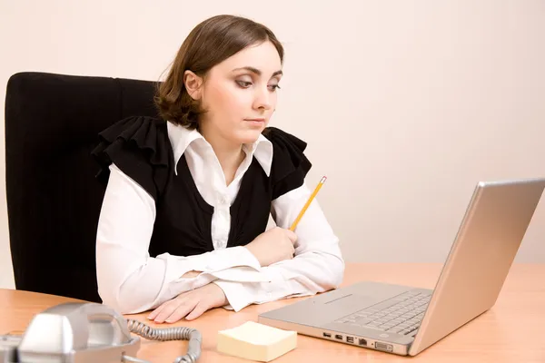 Secretária jovem com telefone, laptop e lápis pensando — Fotografia de Stock