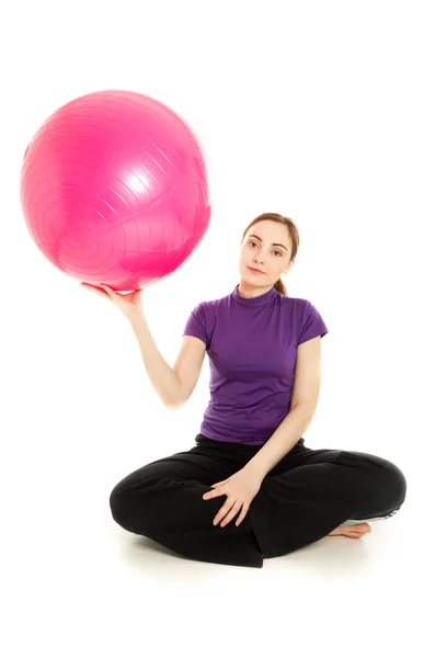 Mujer con bola rosa haciendo ejercicio aislado — Foto de Stock