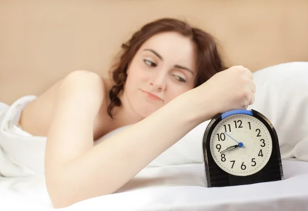 Mulher deitada em uma cama e pressione um alarme (foco no alarme ) — Fotografia de Stock