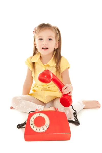 Kleines Mädchen mit altem rotem Telefon — Stockfoto