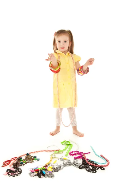 Little girl with a lot of jewel standing on the floor isolated o — Stock Photo, Image