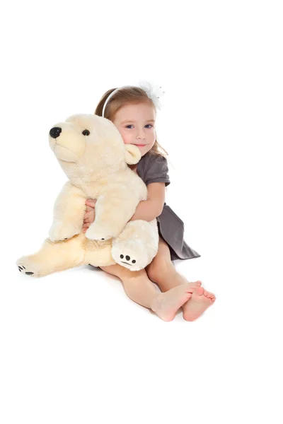Маленькая девочка с игрушкой сидит на полу — стоковое фото