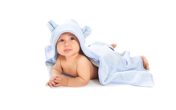 Vacker baby visar hennes tunga under blå handduk — Stockfoto