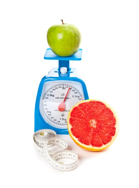 A piece of grapefruit, an apple, measure tape and scale — Stock Photo, Image