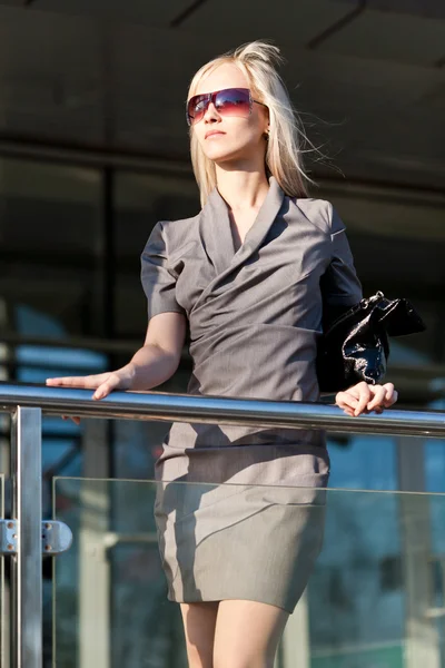 Schöne Frau im grauen Kleid in der Nähe des Geschäfts — Stockfoto