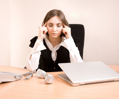 Young businesswoman massaging temples clipart