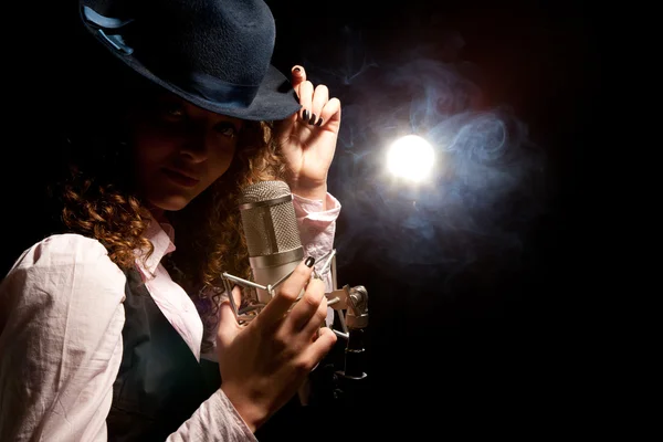 Piękna piosenkarka w kapeluszu z mikrofonem — Zdjęcie stockowe