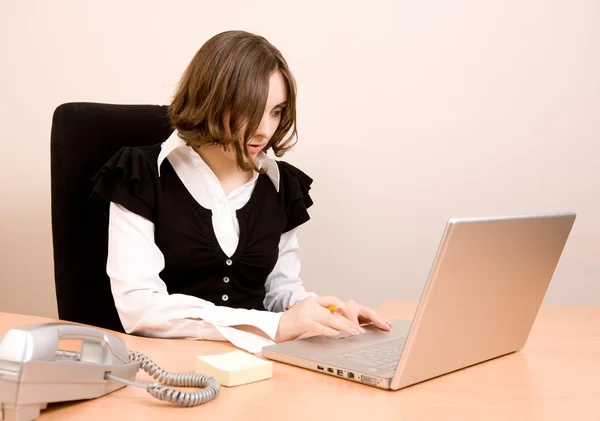 Mladá sekretářka s telefonem a laptop — Stock fotografie