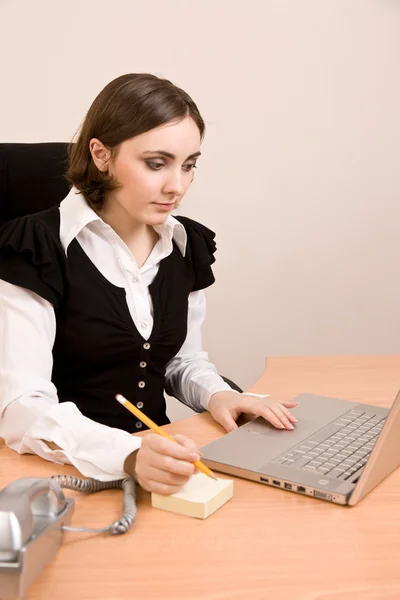 Joven secretaria con teléfono, ordenador portátil y pensamiento a lápiz — Foto de Stock