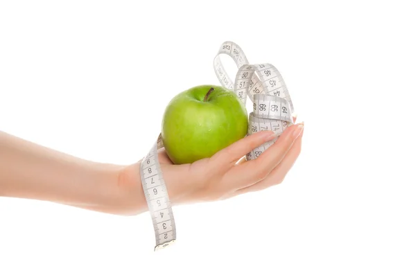 Woman's hands holding green apple with measuring tape — Stock Photo, Image