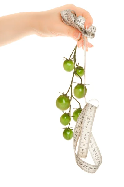 Woman's hands holding green tomatoes with measuring tape — Stock Photo, Image