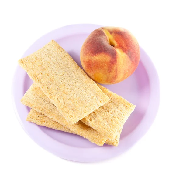 Stock image A plate with peach and three crisps