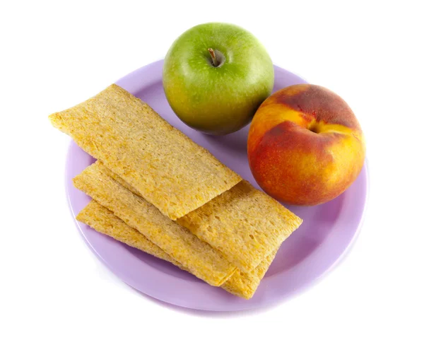Een bord met groene appel, perzik en drie chips — Stockfoto