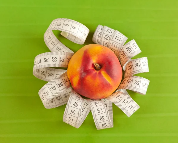Picture of a peach and tape measure — Stock Photo, Image