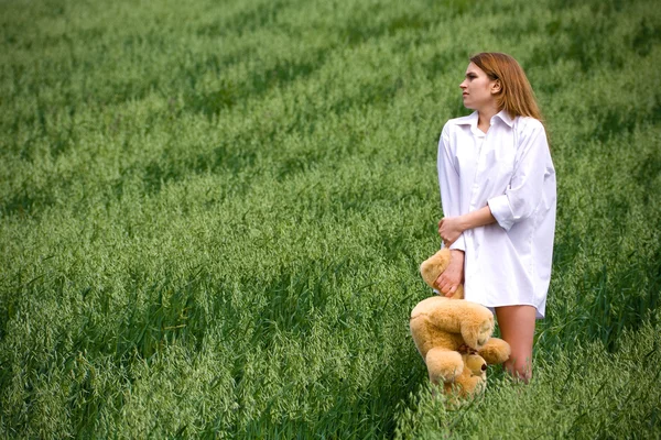 Frozen woman with a bear in grass — Stock Photo, Image