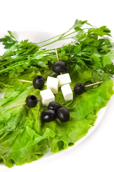 Канапе и салат на белой тарелке — стоковое фото