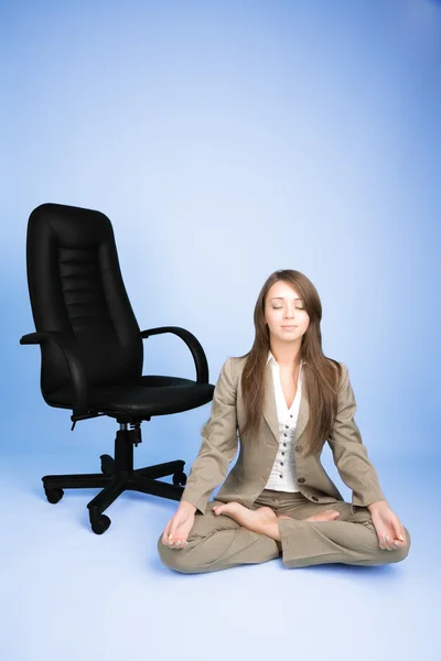 Young woman in costume sitting in lotus pose on the floor — Stock Photo, Image