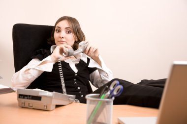 Young secretary with telephone and laptop clipart