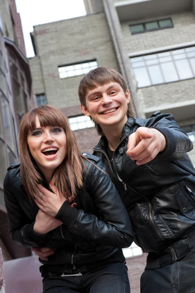 Foto einer lächelnden Frau und eines Mannes, der mit dem Finger in die Kamera zeigt — Stockfoto