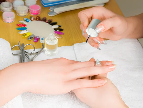 Vrouw handen met nagel borstel tekening op nagels — Stockfoto