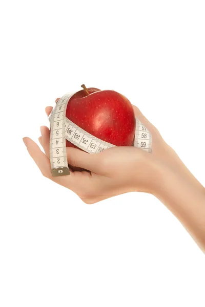 Manos de mujer sosteniendo manzana roja con cinta métrica — Foto de Stock