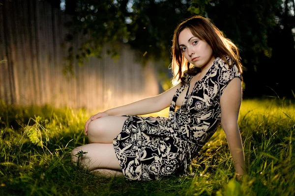 Jonge vrouw zittend op het gras — Stockfoto
