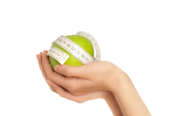 Woman's hands holding green apple with measuring tape — Stock Photo, Image