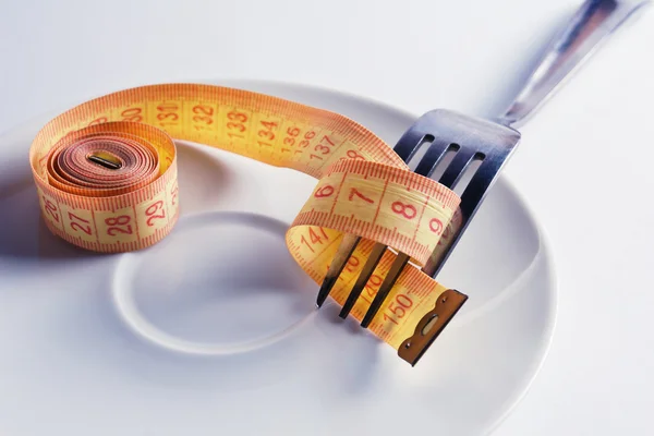 Measuring tape on a plate with fork — Stock Photo, Image
