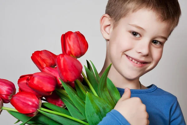 Молодий хлопчик тримає тюльпани — стокове фото