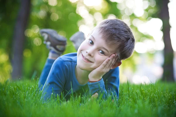 Glad liten pojke på gräset — Stockfoto
