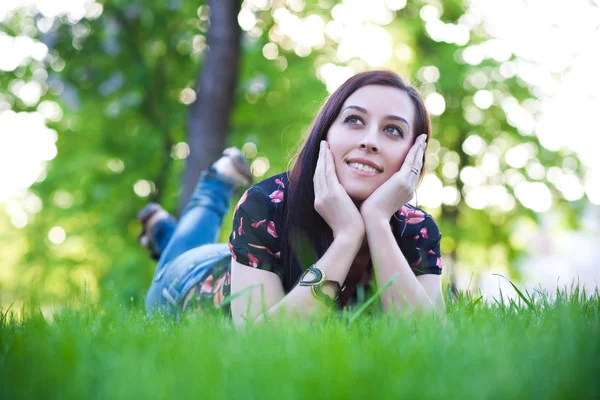 Gelukkig mooi meisje opleggen op het gras — Stockfoto