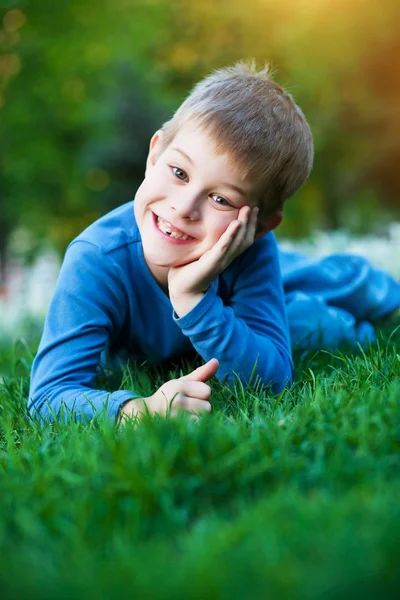 Весела маленька дитина лежить на траві — стокове фото