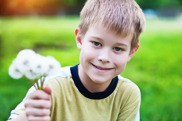 Усміхнений хлопчик з кульбабами — стокове фото
