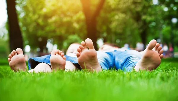 Nohy na trávě. rodinný piknik v parku na jaře — Stock fotografie