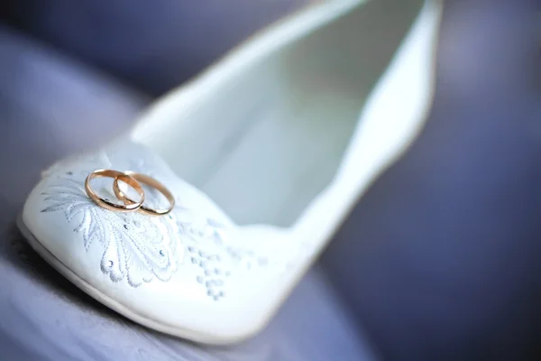 Обручальные кольца на белых туфлях — стоковое фото