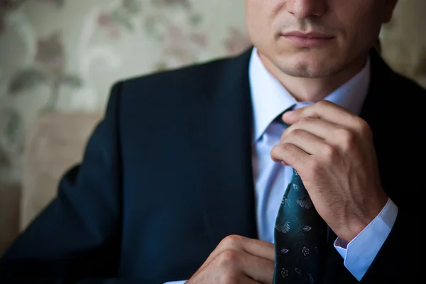 Businessman in suit adjusts his tie — Stock Photo, Image