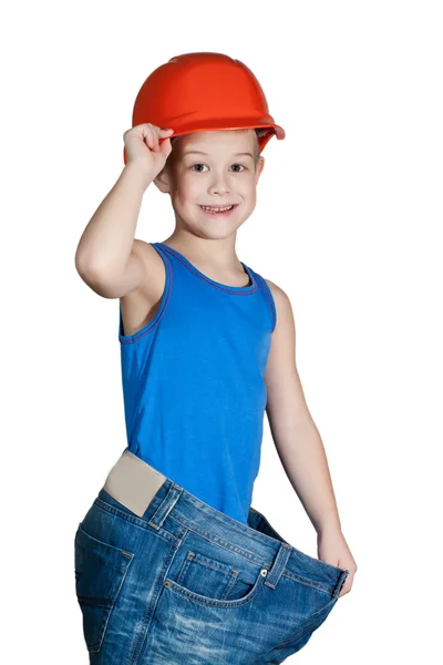 Маленький мальчик в каске и слишком больших джинсах — стоковое фото