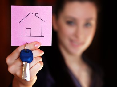 Happy woman holding a little red note in her hands clipart