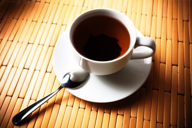 Bambu zemin üzerine beyaz bir bardak çay
