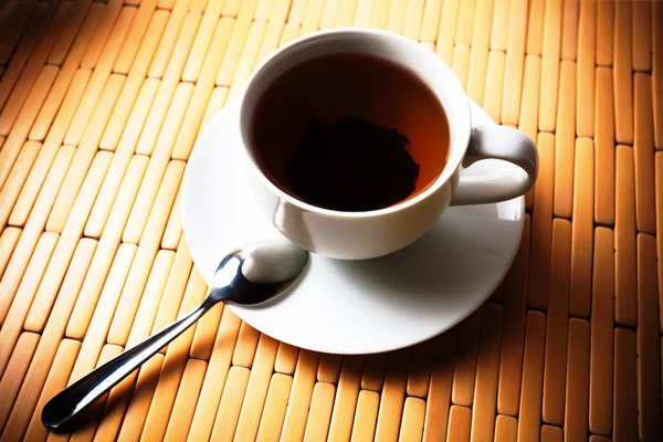 Xícara de chá em uma xícara branca em um fundo de bambu — Fotografia de Stock