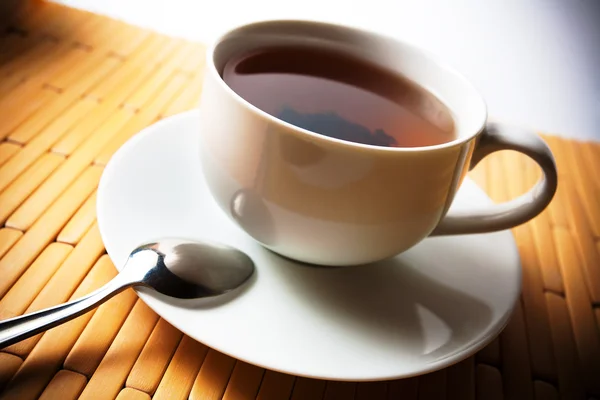 Xícara de chá em uma xícara branca em um fundo de bambu — Fotografia de Stock