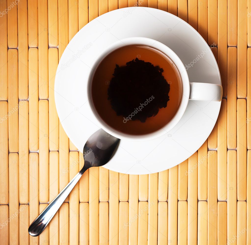 Cup of tea in a white cup on a bamboo background
