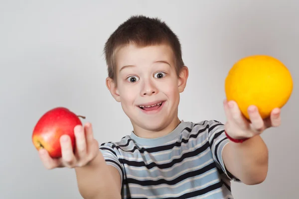 Маленький хлопчик тримає фрукти — стокове фото