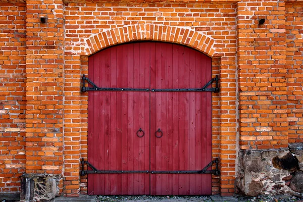 Puerta roja en la pared de ladrillo rojo — Foto de Stock