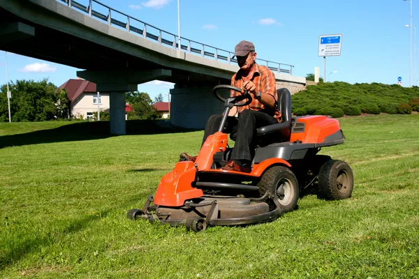 Homme sur un tracteur de pelouse — Photo